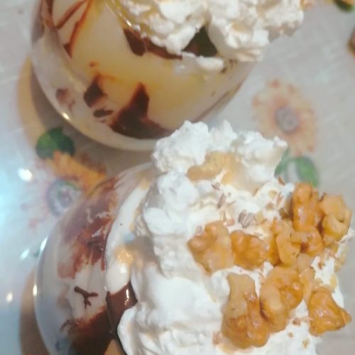 Un pahar cu mousse de vanilie frișcă și nuci