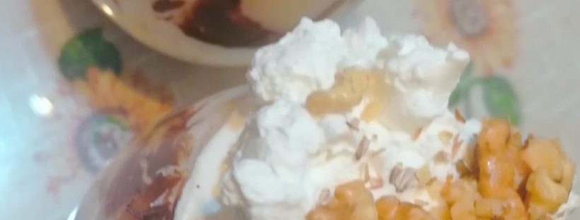 Un pahar cu mousse de vanilie frișcă și nuci